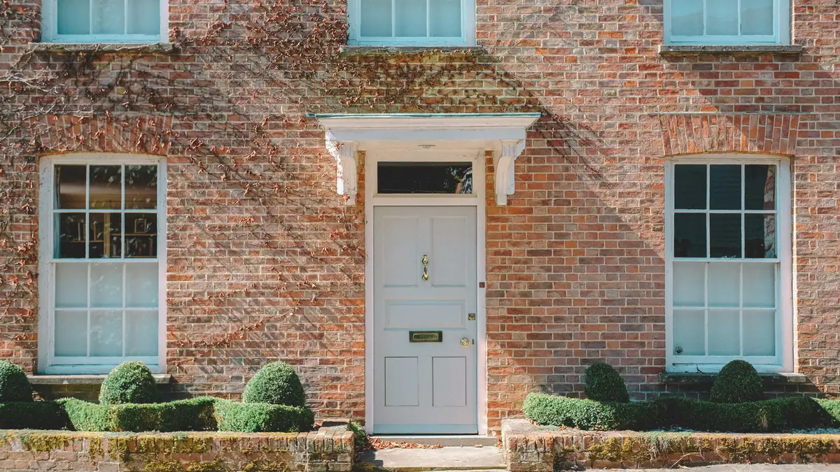 The brick entrance of the office building, with a white door, so you know what to look for when you arrive