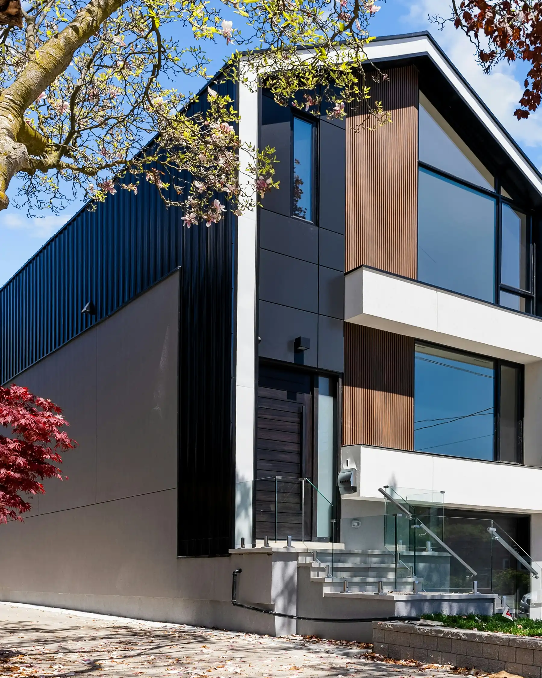 Sharp modern black-and-timber house exterior with an angular roofline