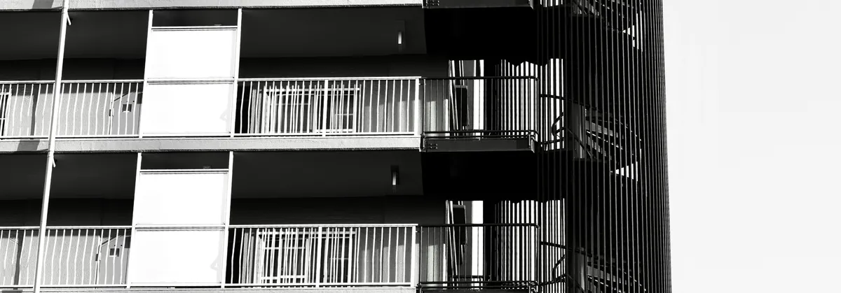 Black-and-white modern apartment building facade with repeating balconies