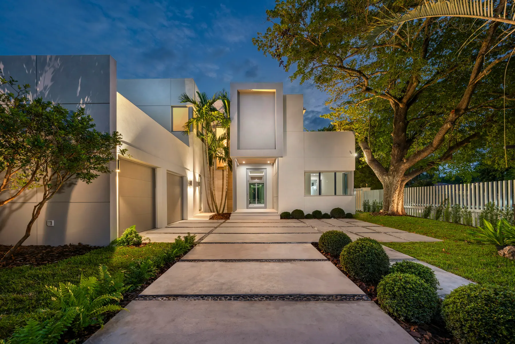 Modern luxury home exterior illuminated at dusk
