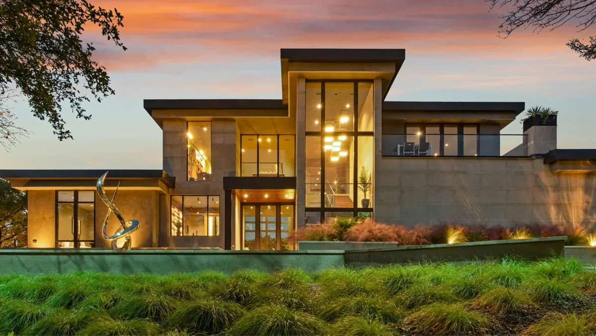 Modern home exterior with large windows at dusk